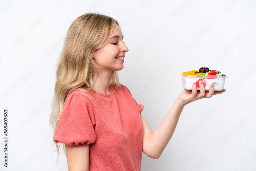 Young English woman holding a bowl of fruit over isolated white background with happy expression Young English woman holding a bowl of fruit over isolated white background with happy expression