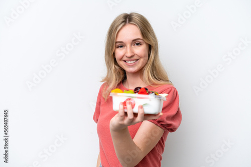 Young English woman holding a bowl of fruit over isolated white background with happy expression