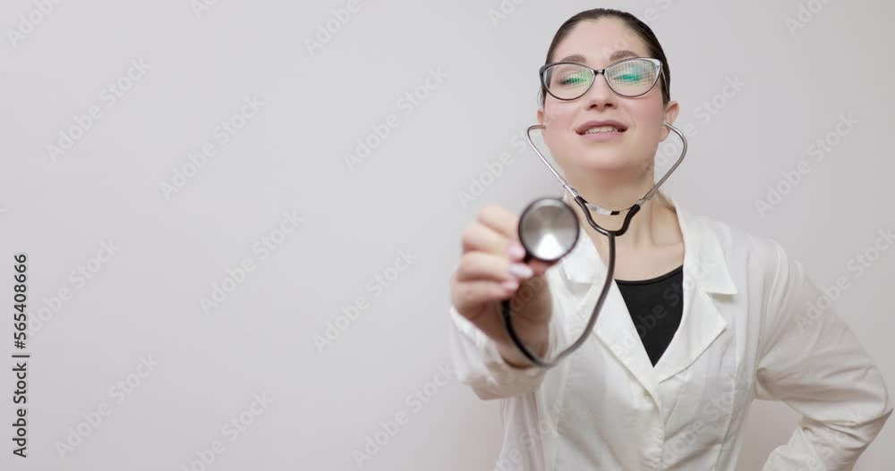 Young european female general practitioner with glasses in a white medical coat and with a stethoscope. Close up positive portrait of general practitioner
