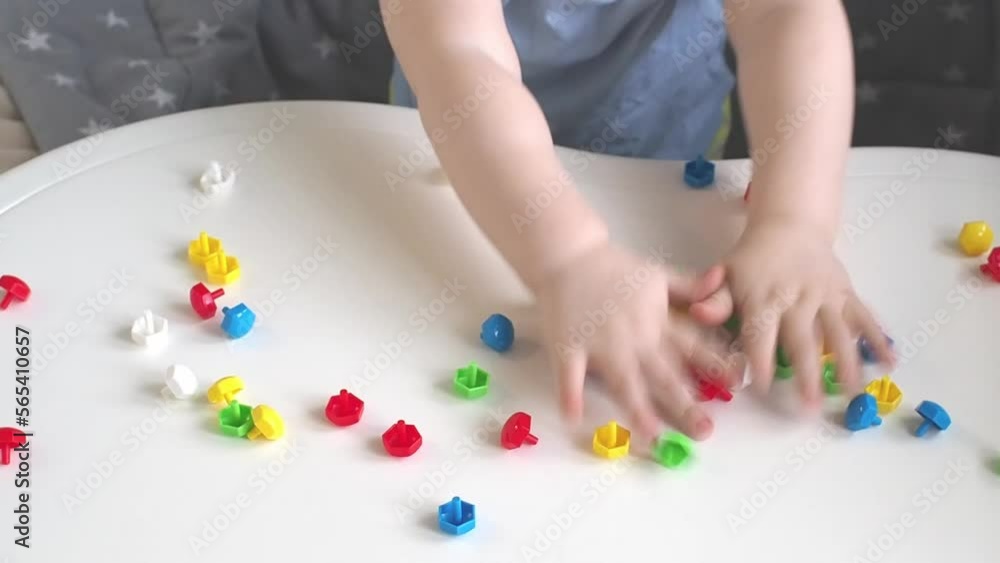 Little child throws mushroom nail mosaic constructor from the table. Little child throws mushroom nail mosaic constructor from the table.