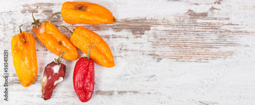 Photography Old moldy peppers on old rustic board, unhealthy and disgusting vegetable