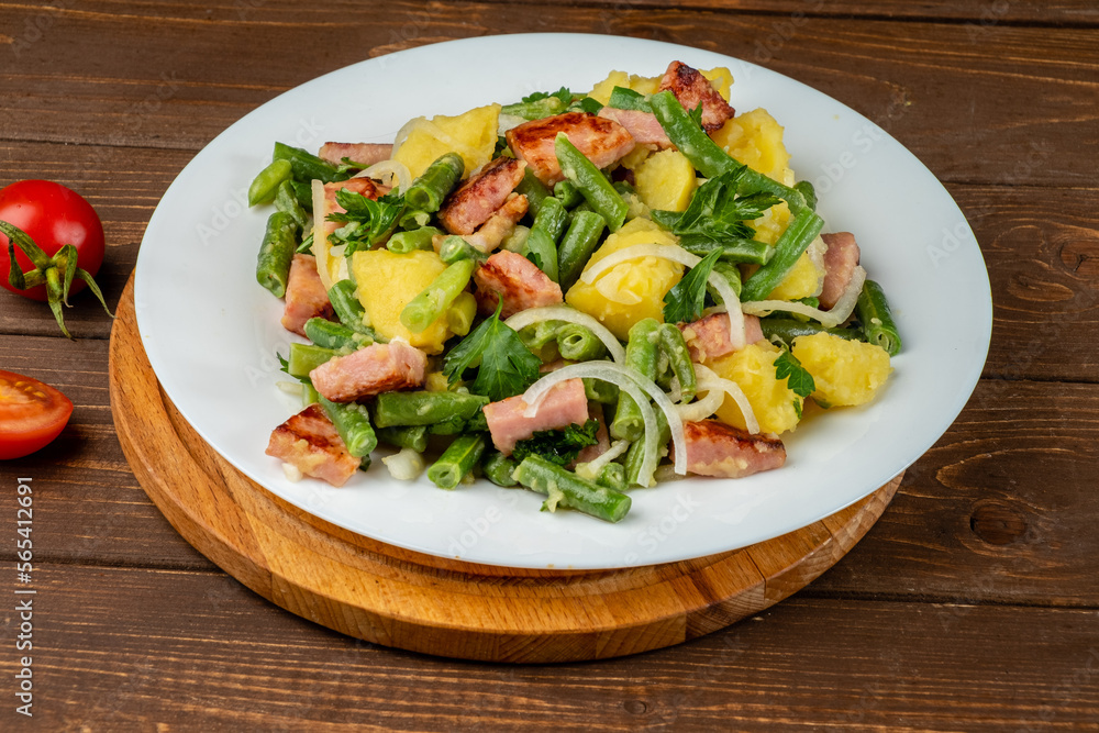 Delicious potato and bean salad, traditional Belgian salad in a white plate on a wooden background. Delicious potato and bean salad, traditional Belgian salad in a white plate on a wooden background.