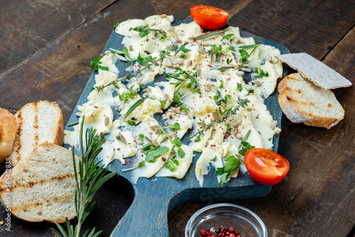 Snack board with butter, herbs and baguette on wooden background. trendy dish. photo