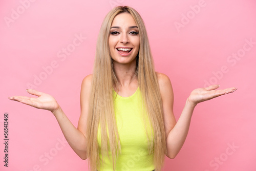 Pretty blonde woman isolated on pink background with shocked facial expression