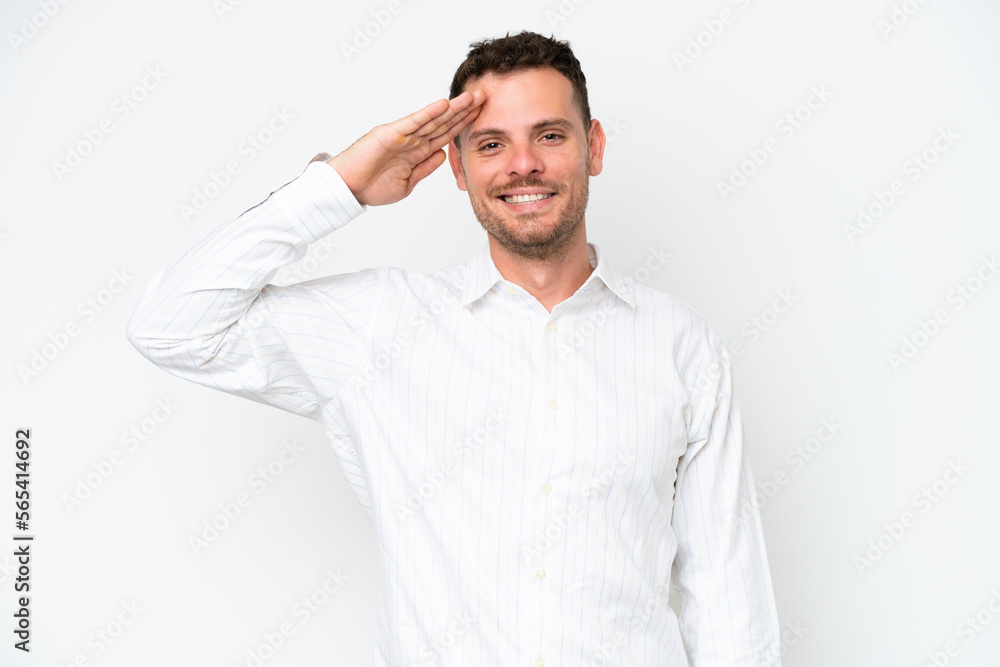 Young caucasian handsome man isolated on white background saluting with hand with happy expression Young caucasian handsome man isolated on white background saluting with hand with happy expression