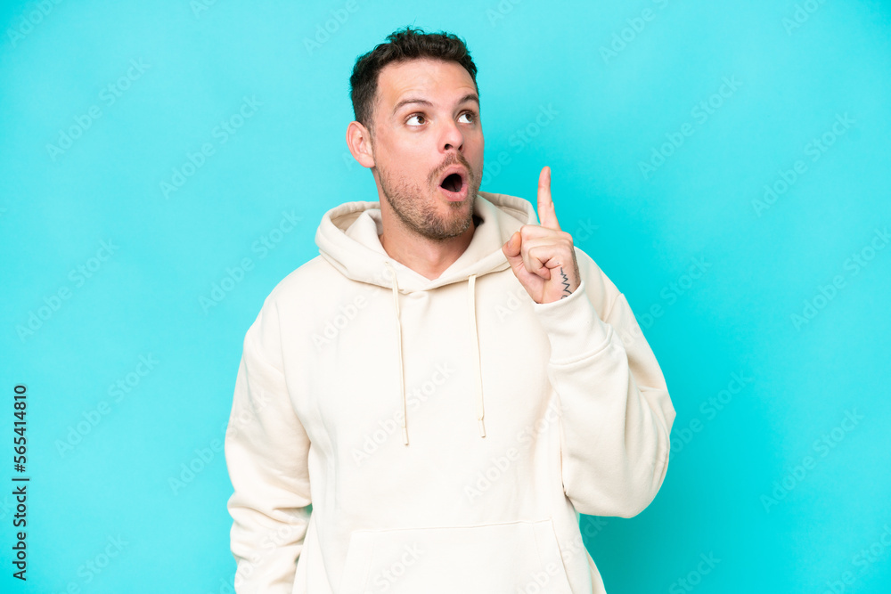 Young caucasian handsome man isolated on blue background thinking an idea pointing the finger up Young caucasian handsome man isolated on blue background thinking an idea pointing the finger up