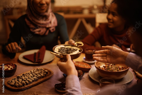 Close up of Middle Eastern family passing food while eating dinner at dining table.