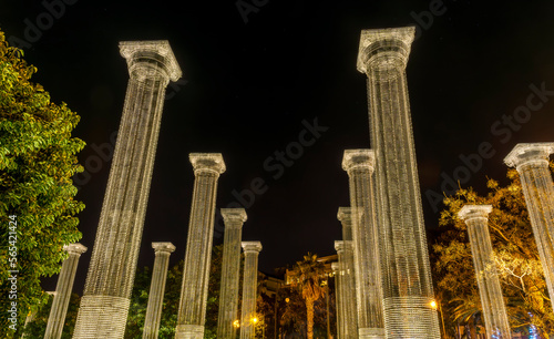 picturesque luminous transpatent columns in park with a night sky background, architecture constructions in ancient roman style