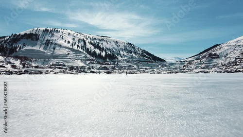 Man walking on frozen lake. lower angle. Image moving towards man.