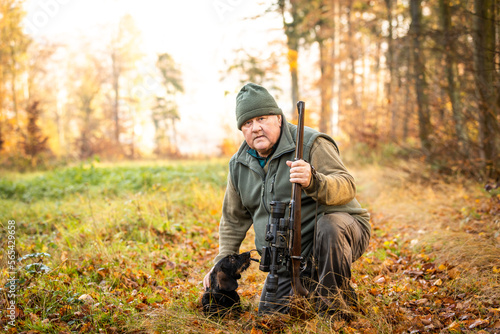 Hunter or ranger with a professional  nightvision hunting gun and hunting form to hunt in an autumn forest  hunting concept