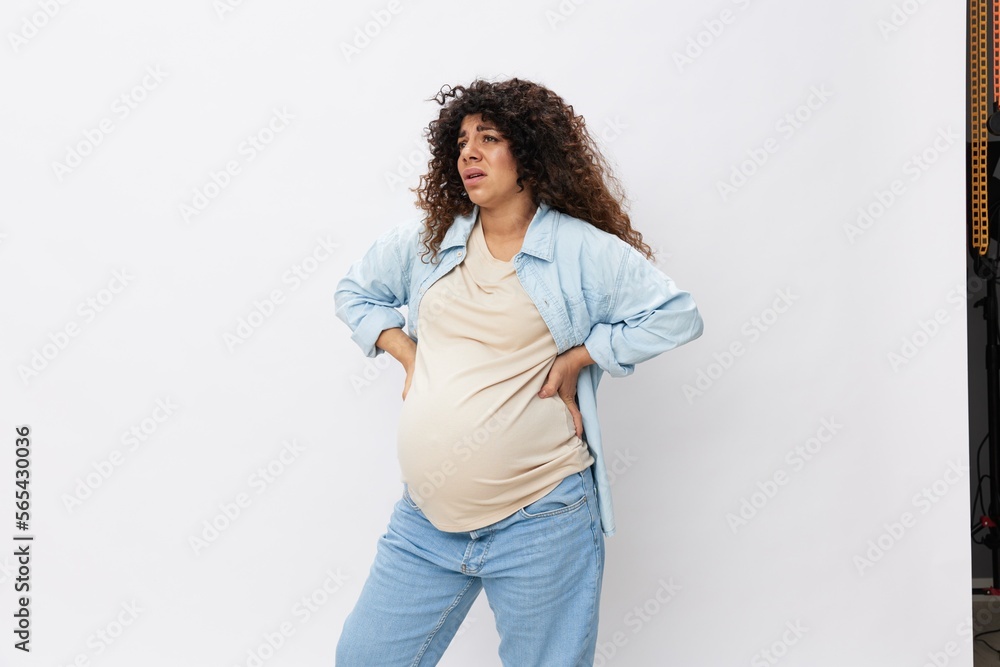 Pregnant woman tired, headache and abdominal pain, heavy pregnancy, last month before childbirth on white isolated background in T-shirt with blue shirt Pregnant woman tired, headache and abdominal pain, heavy pregnancy, last month before childbirth on white isolated background in T-shirt with blue shirt