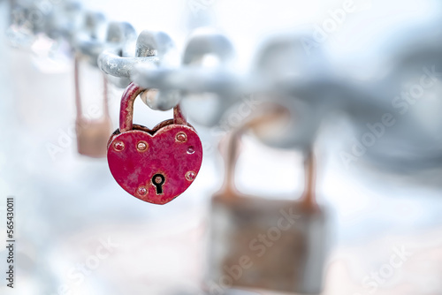 Red heart shaped lock hangs from chain, wedding custom, concept of love and health