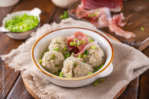 Canederli or Knodel in broth with green onion. North italian traditional dish, typical pasta for Trento, Alps, Alto Adige, Italian, Austrian cuisine. 