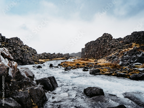 A river that quickly meanders between two rock walls on a cloudy day