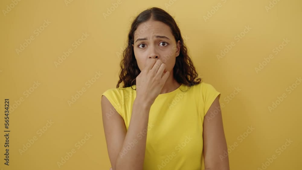 Young african american woman standing with nervous expression over isolated yellow background Young african american woman standing with nervous expression over isolated yellow background