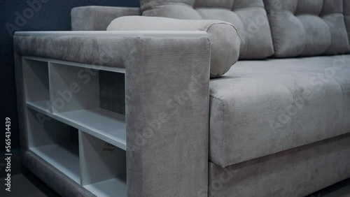 Gray sofa with decorative pillows. Sofa equipped with white side shelves. 4k video