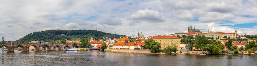 waterfront view across the river Vltava to Castle, Charles Bridge and Petrin Lookout tower, Prague, Czech republic