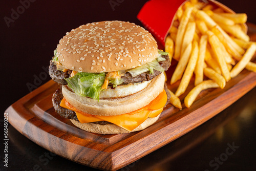 Delicious hamburger with two meats, cheddar cheese, fried egg, sauce and salad. Accompanied by french fries.
