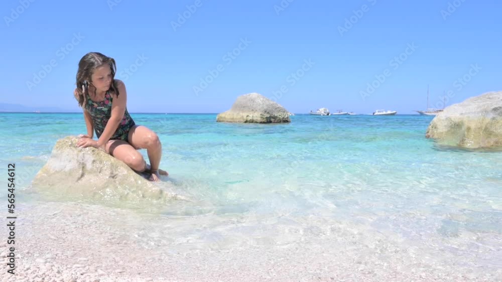 Little girl on the beach plays in the waves. Pure azure sea and sun glare. Happy moment for a child. High quality FullHD footage Little girl on the beach plays in the waves. Pure azure sea and sun glare. Happy moment for a child. High quality FullHD footage
