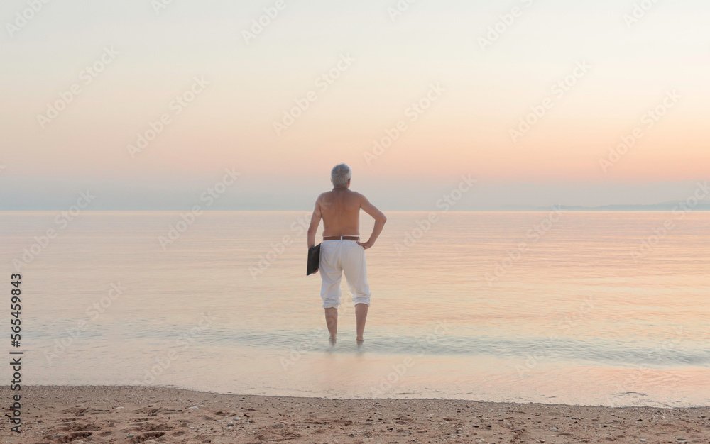 from back man with notebook standing  in the sunset sea 