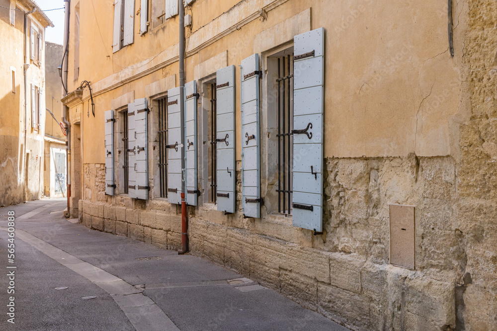 Windows with wooden shutters along a narrow street.