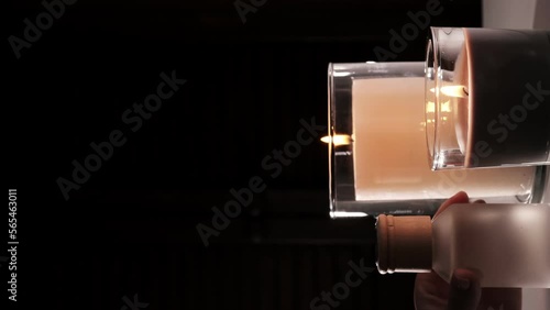 Female hands put sticks into a bottle of air freshener. Aromatherapy. Aroma diffuser. Comfort in the dark, candles.