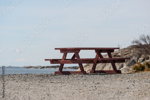 Wooden park bench and table by the sea.