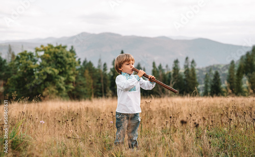 Folk music. Little boy playing on woodwind wooden flute - ukrainian sopilka © kohanova1991