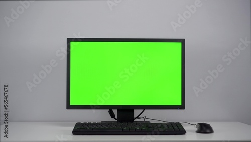 Green screen on a computer monitor in the office. Chroma key on pc.