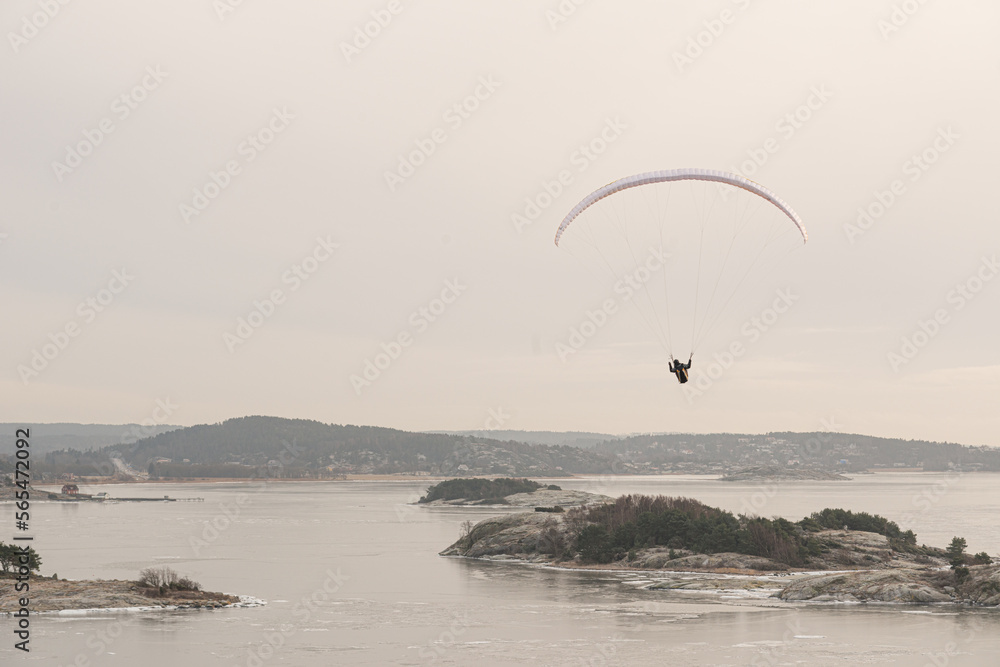 Paraglider gliding over an icy fjord. Paraglider gliding over an icy fjord.