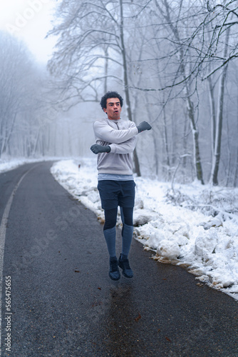 Warm up before going on a run in the foods on a snowy winter day, trees and ground are cover in snow