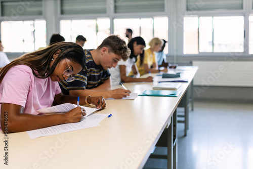 Group of high school students doing an exam test in classroom
