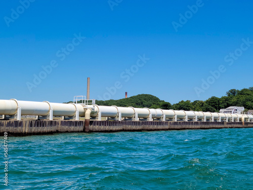 White industrial pipeline on Lake Michigan with bright blue sky  