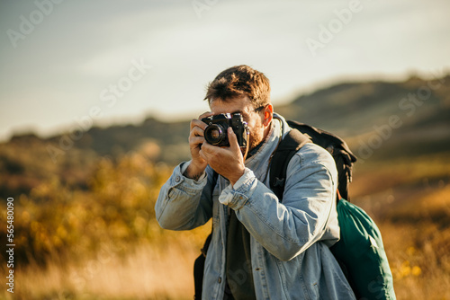Young photographer hiking on mountains and photographing nature. © La Famiglia