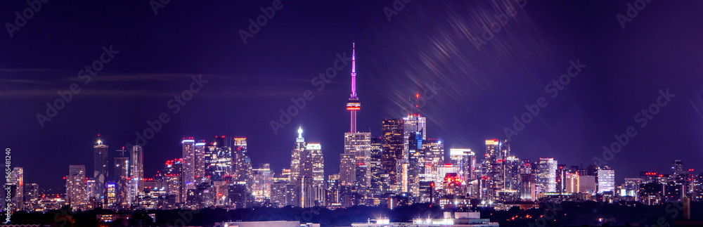 Naklejka premium Toronto skyline at night with buildings street lights. Toronto, Ontario, Canada. Down town city skyline and panorama with urban areas. Sky with lights leaks.