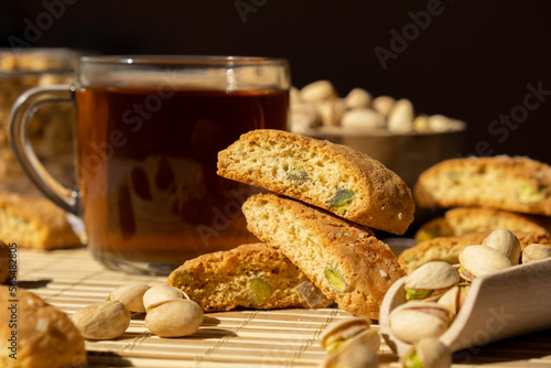 Biscotti Cantuccini Cookie Biscuits with pistachios and lemon peel Shortbread. Cup of tea. Teatime break Healthy eating food. Homemade fresh Italian cookies cantucci stacks and organic pistachios nuts