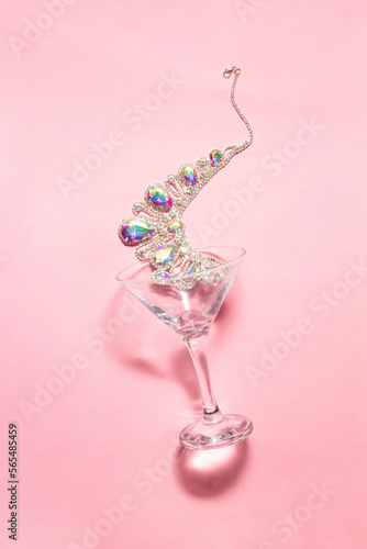Tasty drink with gems in glass on light pastel pink background. Creative beverage concept. Minimalistic rich flavor composition. Sunny summer day idea.