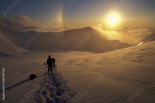 USA, Alaska, Denali National Park, (MR) Expedition descends Kahiltna Glacier at sunset at 11,000' during Mount McKinley climb photo