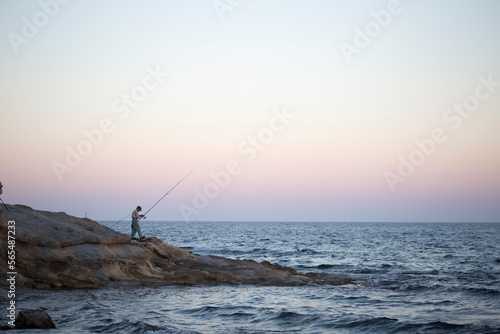 A man fishing in Calpe at sunset photo