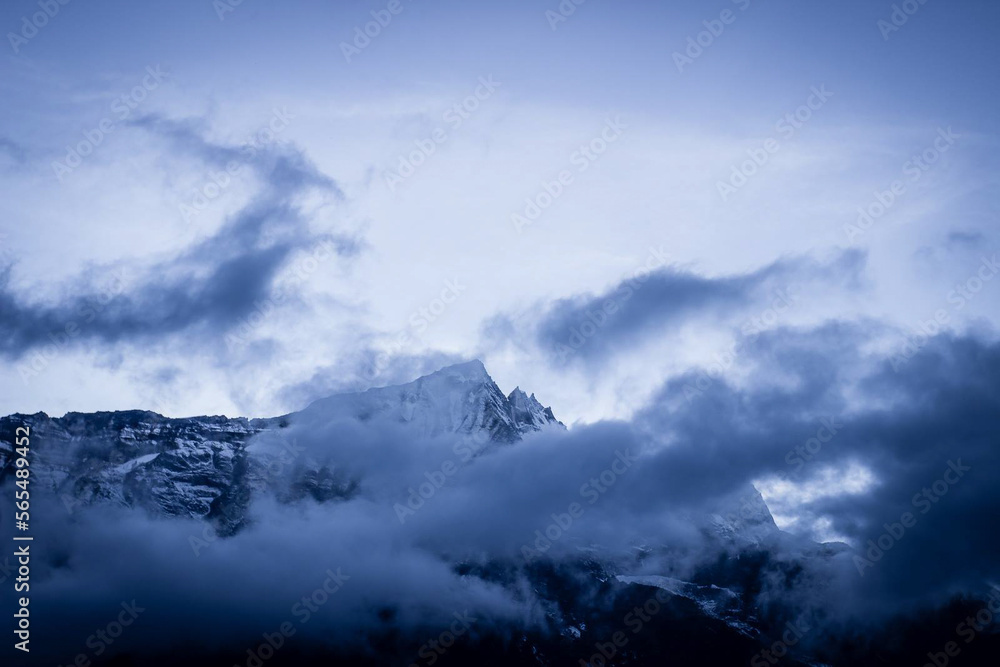 Clouds blow across the Himalayan peaks at twilight