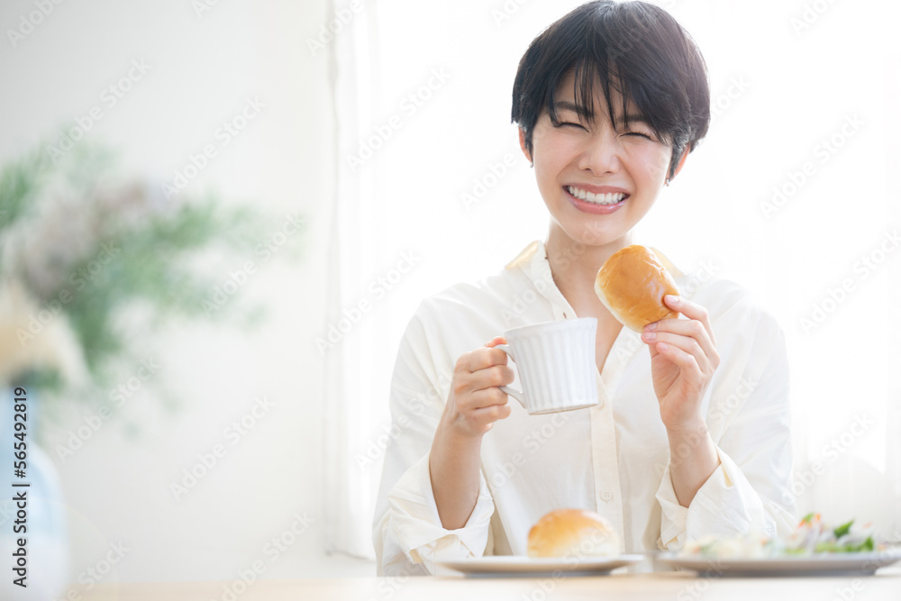 Asian woman eating bread Beautiful fresh breakfast scene with sunrise Green foreground blurring Looking at the camera Asian woman eating bread Beautiful fresh breakfast scene with sunrise Green foreground blurring Looking at the camera