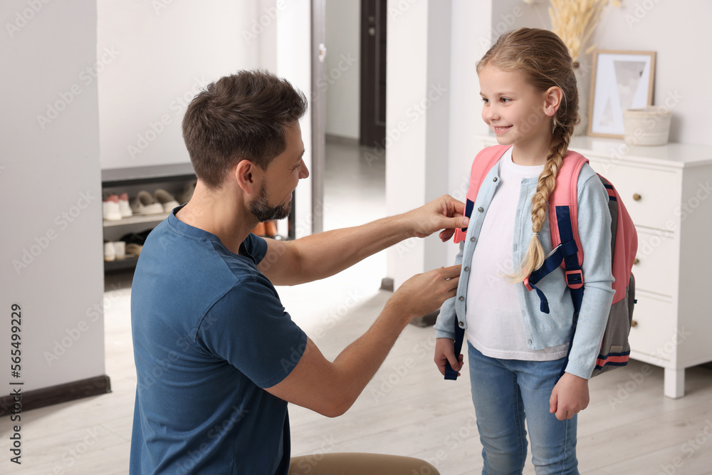 Obraz premium Happy father preparing his smiling daughter to school at home