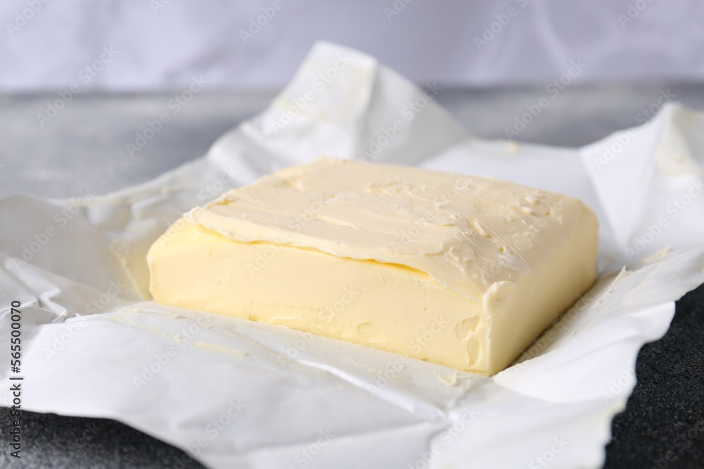 Piece of tasty homemade butter on paper wrap, closeup Piece of tasty homemade butter on paper wrap, closeup