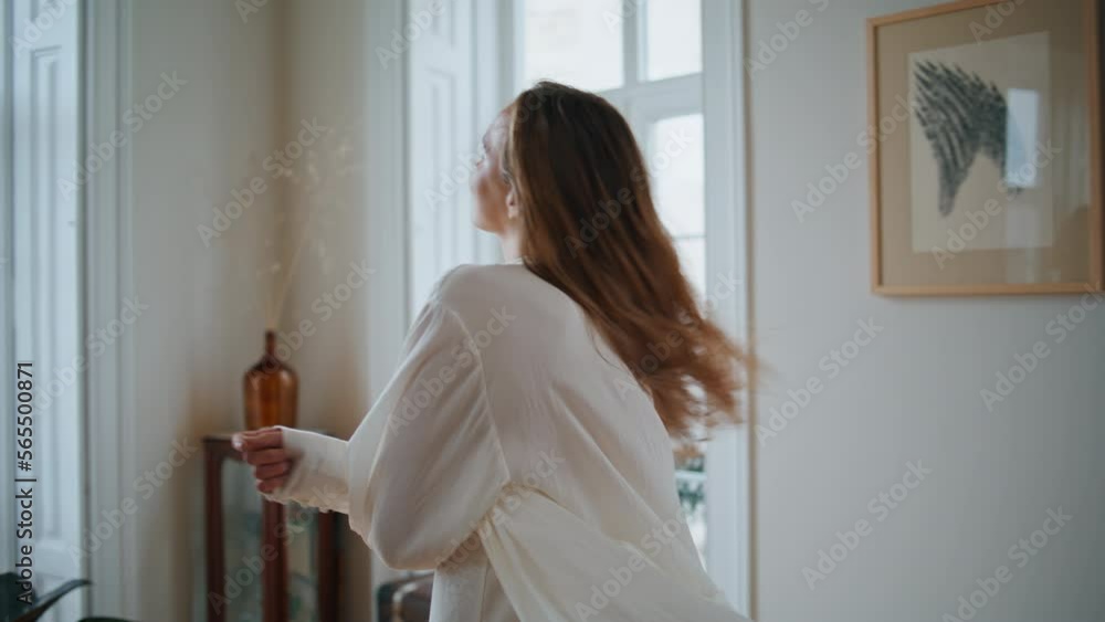 Dancing woman swirling home closeup. Relaxed lady in silk robe watching window