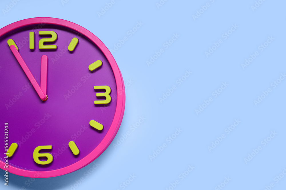 Clock showing five minutes until midnight on light blue background, top view with space for text. New Year countdown Clock showing five minutes until midnight on light blue background, top view with space for text. New Year countdown