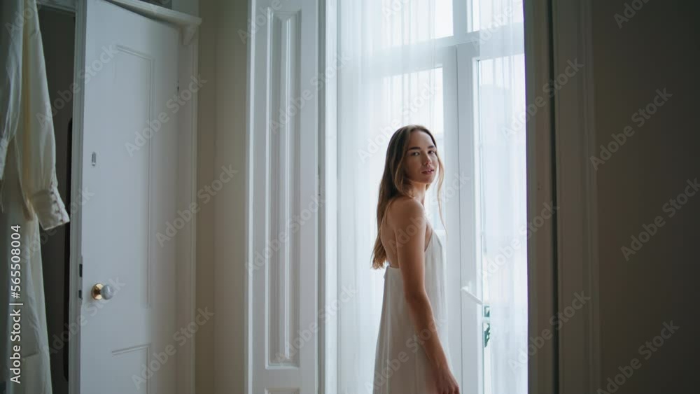 Tender lady posing window interior. Woman looking camera relaxing at bedroom Tender lady posing window interior. Woman looking camera relaxing at bedroom