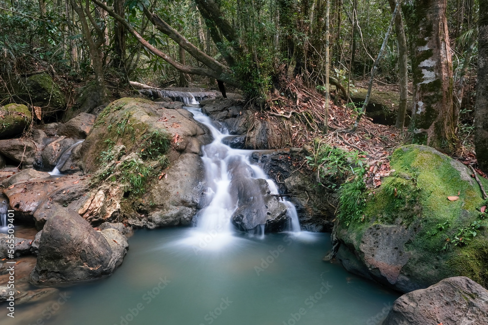 Long exposure shot of a cascede on the creek in the forest on cloudy day. Dragon's Crest (Ngon Nak) hiking trail, Krabi Province, Thailand.