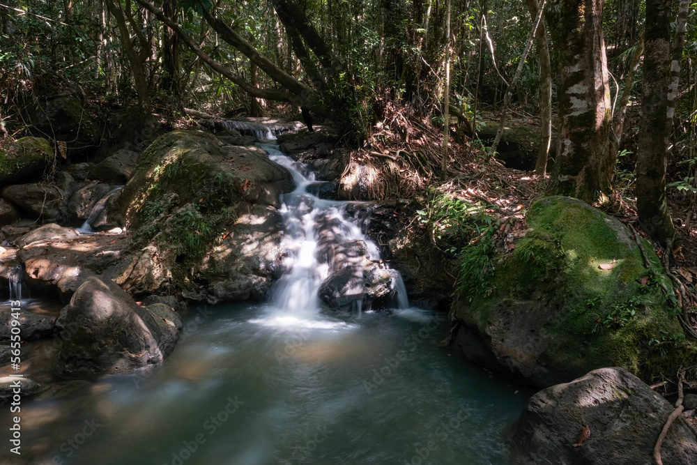 Long exposure shot of a cascede on the creek in the jungle on sunny day. Dragon's Crest (Ngon Nak) hiking trail, Krabi Province, Thailand. Long exposure shot of a cascede on the creek in the jungle on sunny day. Dragon's Crest (Ngon Nak) hiking trail, Krabi Province, Thailand.