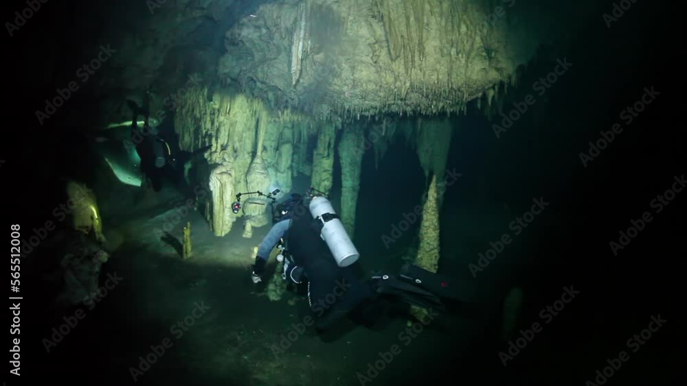 Divers in rocks of underwater cave Yucatan Mexico cenotes. Diving in clean and clear underground water. Divers in rocks of underwater cave Yucatan Mexico cenotes. Diving in clean and clear underground water.