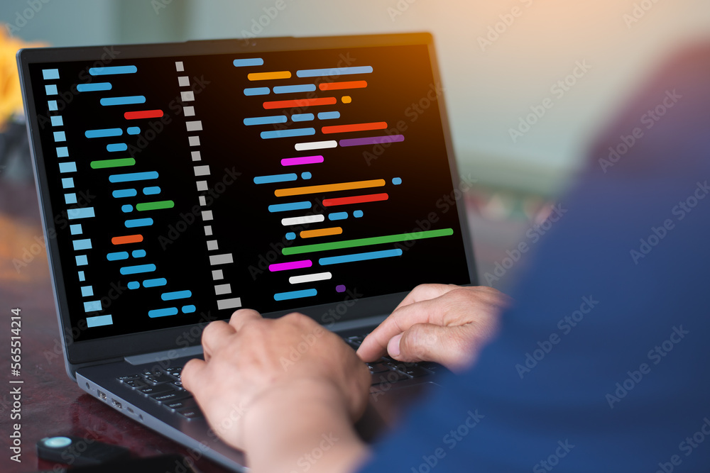 A man is typing on the laptop with virtual code graphic on screen A man is typing on the laptop with virtual code graphic on screen